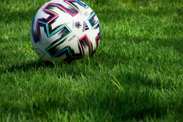 Colorful soccer ball resting on a grassy field.